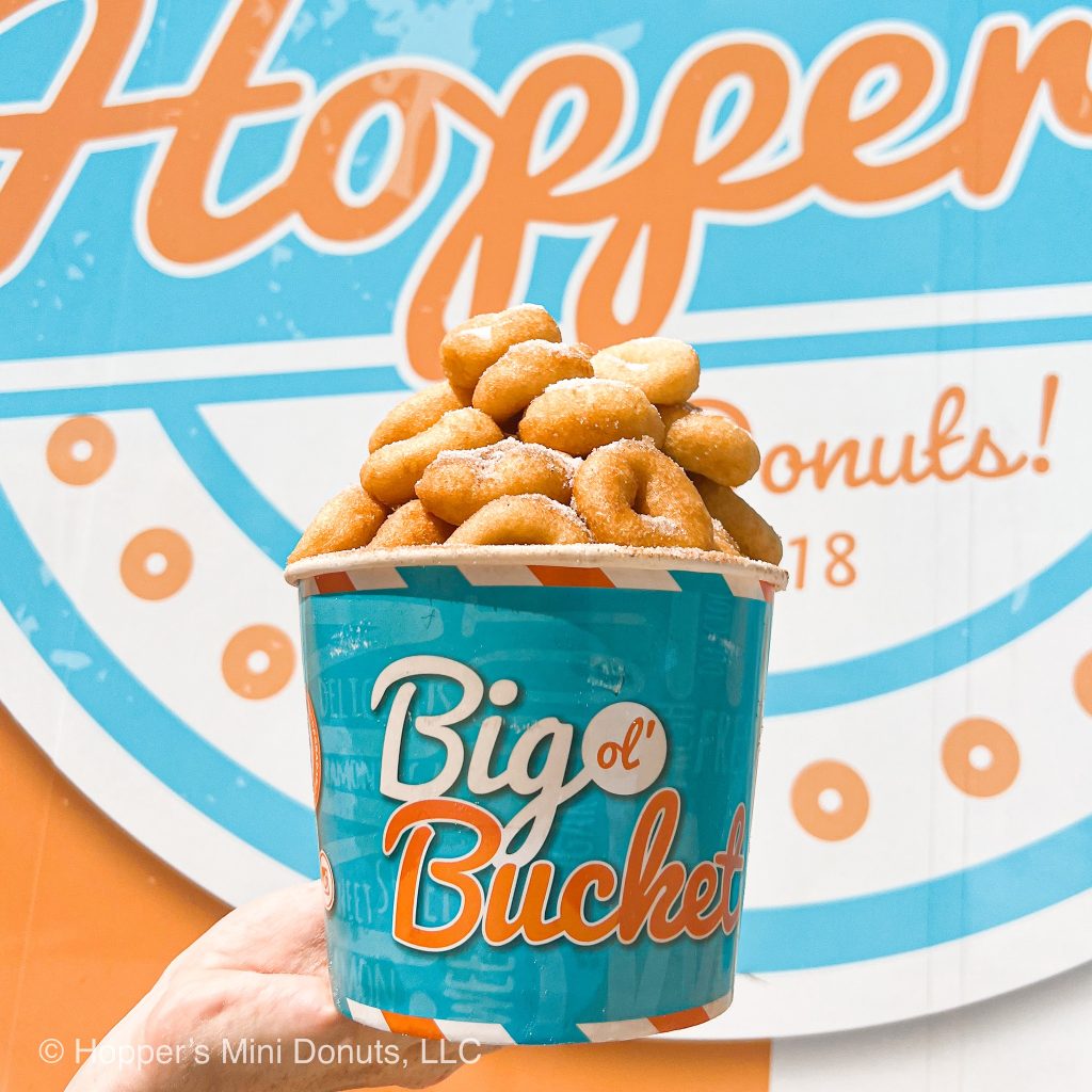 Bucket filled with powdered sugar mini donuts from Hopper’s Mini Donuts